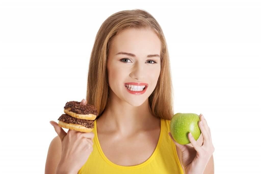 Beautiful caucasian casual woman with doughnuts and apple. Isola